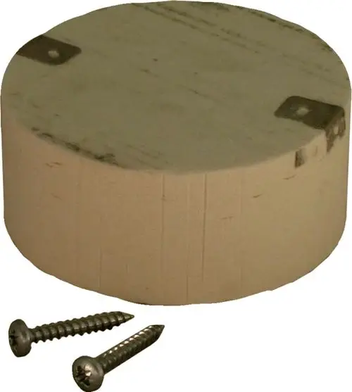 Runder, heller zylindrischer Block aus Holz mit zwei metallischen Halterungen auf der Oberseite und zwei Schrauben im Vordergrund. Produkt von Wolf.